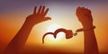 Symbol of freedom with the handles of a prisoner without his handcuffs in front of a sunset. Royalty Free Stock Photo