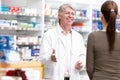 Maintaining client relationship. Portrait of handsome mature pharmacist speaking with customer at drugstore. Royalty Free Stock Photo