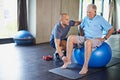 Maintaining his muscles through physiotherapy. Shot of a senior man working out with the help of a trainer. Royalty Free Stock Photo