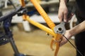 Maintenance of a bicycle: person disassembling an orange bike in his workshop