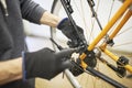 Maintenance of a bicycle: person disassembling an orange bike in his repair shop