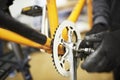 Maintenance of a bicycle: person disassembling an orange bike in his repair shop