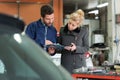 Maintenance engineer with female customer in car repair Royalty Free Stock Photo