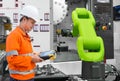 Maintenance engineer testing automatic robotic hand machine tool with CNC machine in automotive industry, Industry 4.0 concept