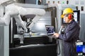 Maintenance engineer using laptop computer control automatic robotic hand with CNC machine in smart factory. Industry 4.0 concept Royalty Free Stock Photo