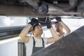 Maintenance engineers repairing car in workshop