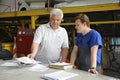 At the maintenance hall. Engineer and worker standing at the working place and communicating. The State Aircraft Repair Plant 410