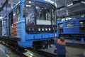 The maintenance hall: female worker washing windows of a subway train parked on the pit