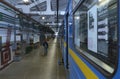 The maintenance hall. Subway trains parked on pits for technical inspection, workers walking the corridor