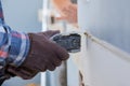 Home remodel of replacement damaged drywall on man is cutting gypsum board with utility hand electric power tools Royalty Free Stock Photo