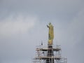 Maintenance, restoration of old Jesus statue, scaffolding on church