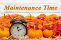 Maintenance Time message with a retro alarm clock with pumpkins and fall leaves