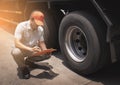 Maintenance and Vehicle inspection. Asian a truck mechanic driver holding clipboard his checking safety a truck wheels and tires. Royalty Free Stock Photo