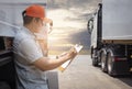 Maintenance and Vehicle safety inspection. Asian a truck driver writing paper on clipboard standing with trailer truck.