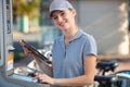 maintenance woman checking parking terminal with tablet