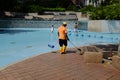 Maintenance worker cleaning a public pool