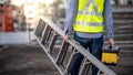 Worker man carrying aluminium ladder and tool box Royalty Free Stock Photo