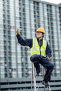 Maintenance worker showing thumb up on ladder Royalty Free Stock Photo