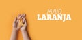 Maio laranja. Hands holding an orange ribbon on an orange background. Concept of protection of children and adolescents from Royalty Free Stock Photo