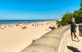 A young woman on the shore of the Baltic Sea gulf looking towards the beach and the sea horison in Jurmala, Latvia