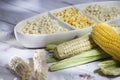 Maize- cob and yellow corn kernels in white glass vase on white wooden background- zea mays Royalty Free Stock Photo