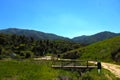 a majestic aerial shot of the lush green hillsides and mountains with a long winding road