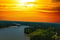 A majestic aerial shot of a rippling lake surrounded by vast miles of lush green trees with a beach on the banks of the lake Royalty Free Stock Photo