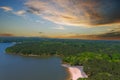 A majestic aerial shot of a rippling lake surrounded by vast miles of lush green trees with a beach on the banks of the lake Royalty Free Stock Photo