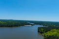 A majestic aerial shot of a rippling lake surrounded by vast miles of lush green trees with a beach on the banks of the lake Royalty Free Stock Photo