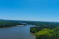 A majestic aerial shot of a rippling lake surrounded by vast miles of lush green trees with a beach on the banks of the lake Royalty Free Stock Photo