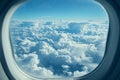 Majestic aerial view of fluffy white clouds under clear blue sky from airplane window Royalty Free Stock Photo