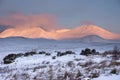 Majestic Alpen Glow hitting mountain peaks in Scottish Highlands during stunning Winter landscape sunrise Royalty Free Stock Photo