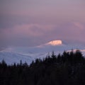 Majestic Alpen Glow hitting mountain peaks in Scottish Highlands during stunning Winter landscape sunrise Royalty Free Stock Photo