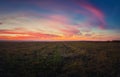 Majestic autumn sunset over a countryside open field. Soft and colorful clouds over empty plain land