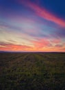 Majestic autumn sunset over a countryside open field. Soft and colorful clouds over empty plain land Royalty Free Stock Photo