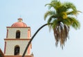 Majestic bending palm tree near a bell tower at the historic Santa Barbara mission Royalty Free Stock Photo