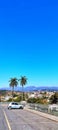 Majestic blue sky with mountains, in an urban landscape with houses, palm trees