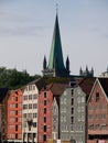 a very tall church spire in the middle of town near the water