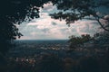 Majestic cloudscape over an urban cityscape seen through tree branches