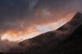 Majestic cloudy sunset in the mountains. Silhouette of mountain hill and peak. Majestic wild nature landscape