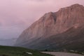 Majestic evening summer mountain landscape - high orange rocky ridge in pink sunlight of sunset, soft mist, Royalty Free Stock Photo