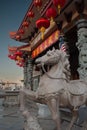 Majestic horse sculpture stands tall outside a grand Chinese temple