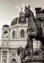 A majestic horseman statue commands attention in the foreground, as the imposing silhouette of a cathedral stands proudly in the