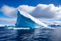 Majestic iceberg floating on tranquil waters under a partly cloudy sky