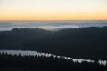 Majestic landscape image of cloud inversion at sunset over Dartmoor National Park in Engand with cloud rolling through forest on