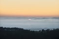 Majestic landscape image of cloud inversion at sunset over Dartmoor National Park in Engand with cloud rolling through forest on