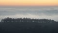 Majestic landscape image of cloud inversion at sunset over Dartmoor National Park in Engand with cloud rolling through forest on