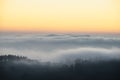 Majestic landscape image of cloud inversion at sunset over Dartmoor National Park in Engand with cloud rolling through forest on