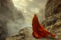 Majestic Lone Figure in Orange Cloak Overlooking Misty Mountainous Landscape at Sunrise