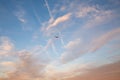 Majestic low angle shot of an airplane flying across a beautifully clouded sunset sky